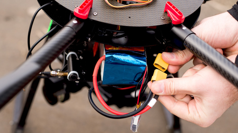 Person inserting battery into drone