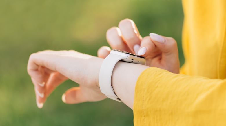 woman tapping smartwatch on wrist