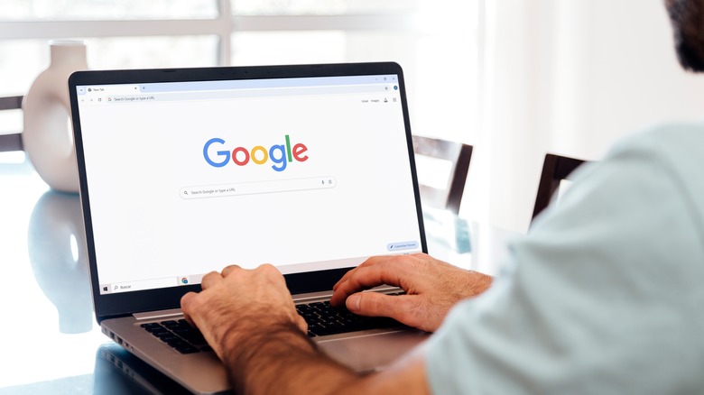 A man using a laptop with the Google Chrome browser opened