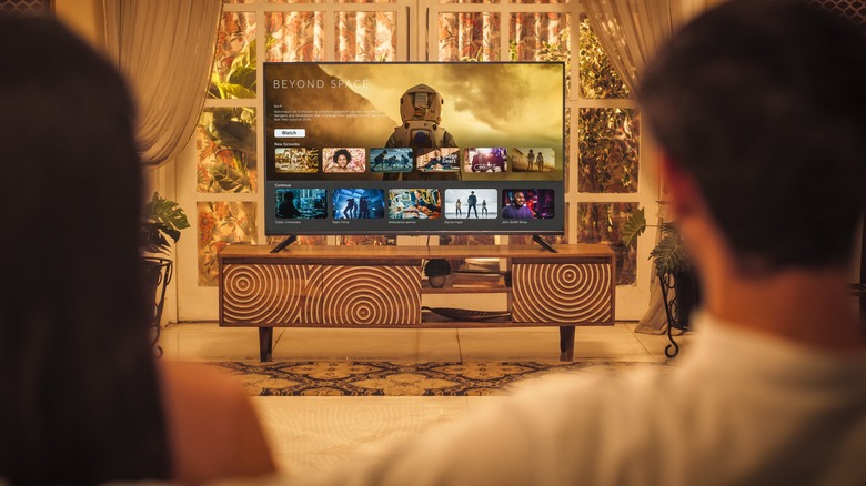 Couple watching TV in their living room