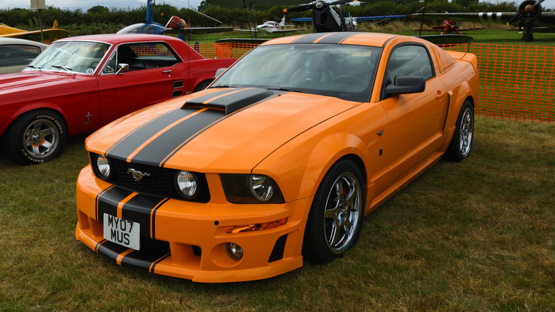 An S197 Ford Mustang Roush 427R in orange with black stripes, front 3/4 view