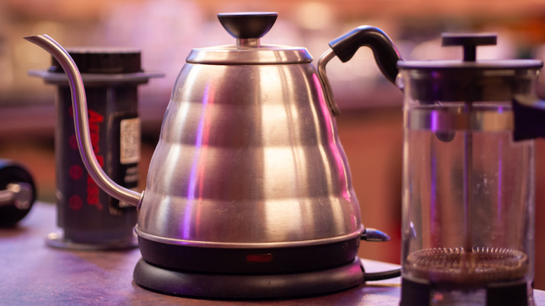 Electric gooseneck kettle sits between an AeroPress (left) and French press (right)