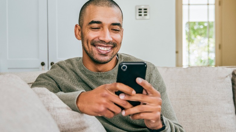 Man on iPhone sitting on couch