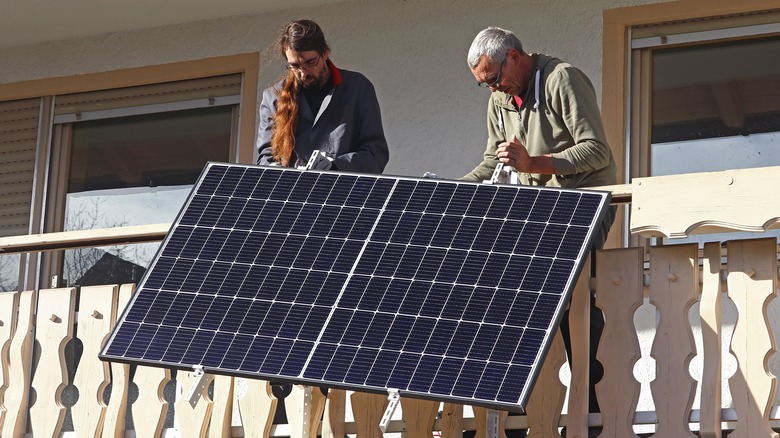 Men installing balcony solar panel