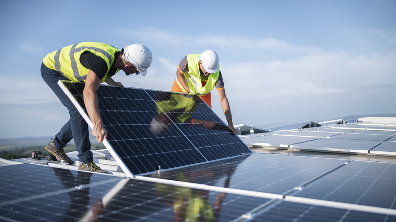 technicians install solar panels