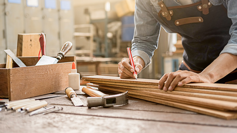 Man marking wood with a pencil