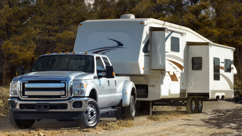 A truck towing an RV on a dirt road