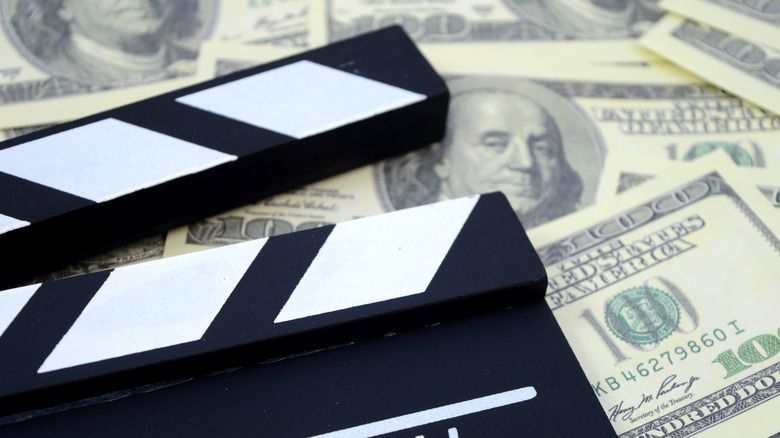 Clapper board on top of $100 bills