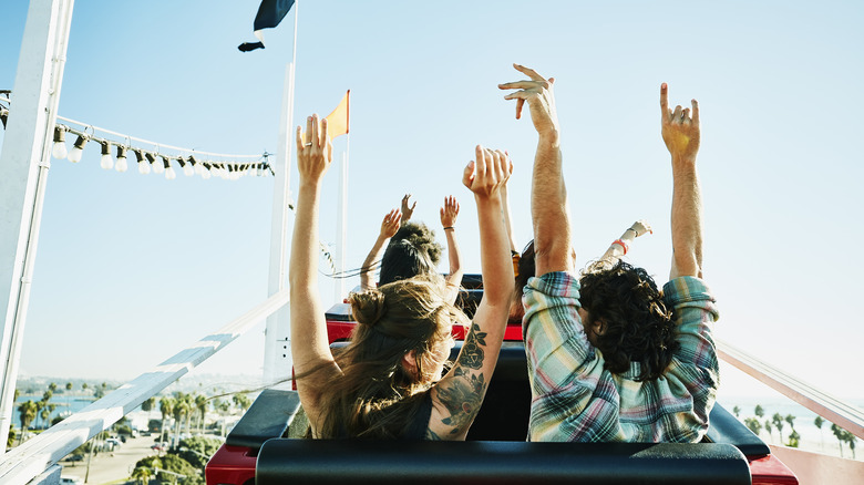 riders on roller coaster from behind