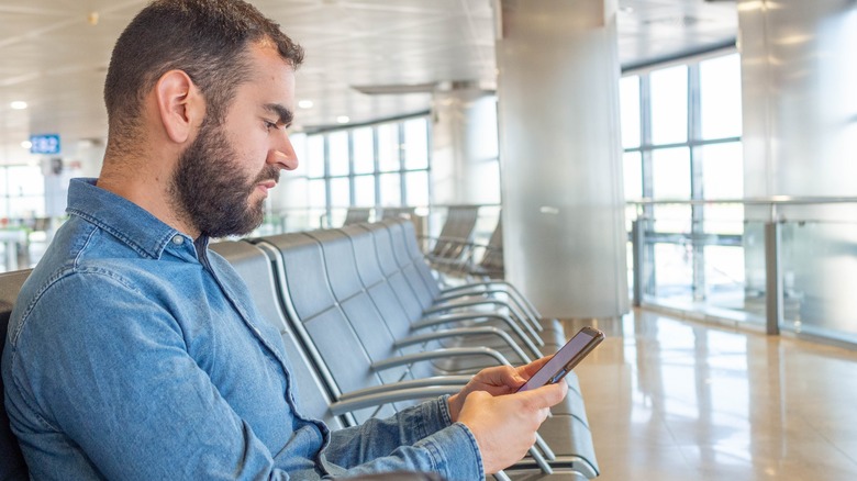 man using cellphone at airport