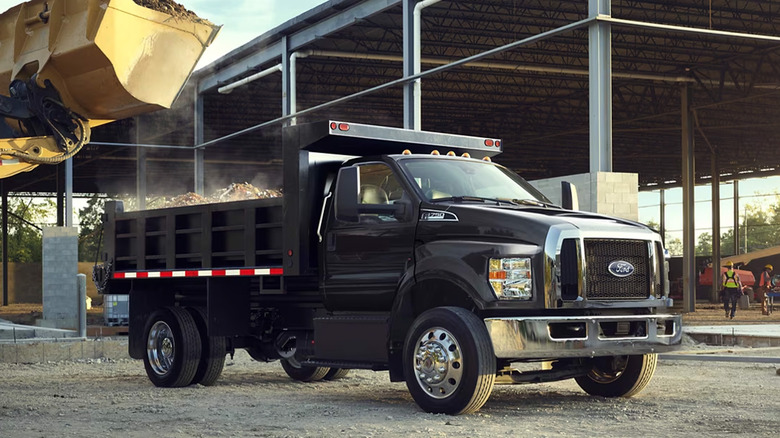 A Ford F-750 being loaded up by a tractor