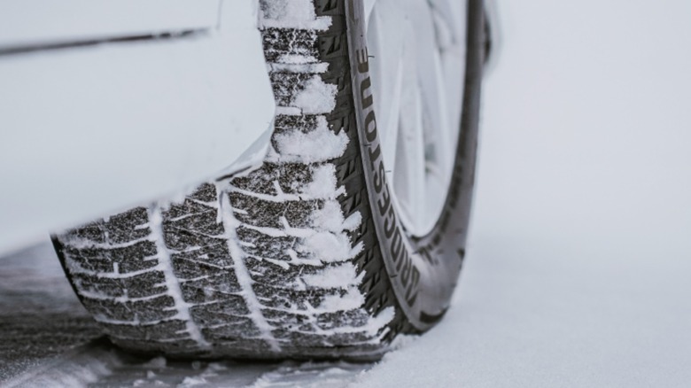 close-up of Bridgestone snow tire on car in snow