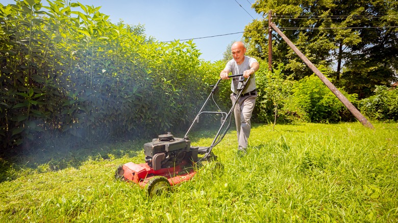 Person mowing with white smoke