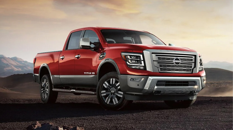 A red Nissan Titan on a gravel path