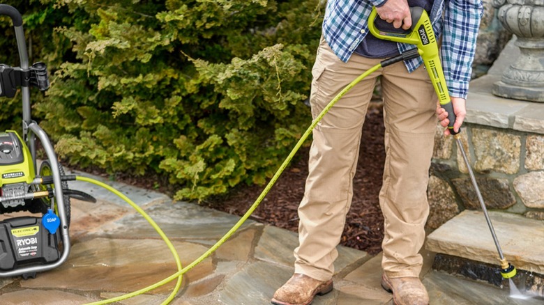 Person using Ryobi pressure washer