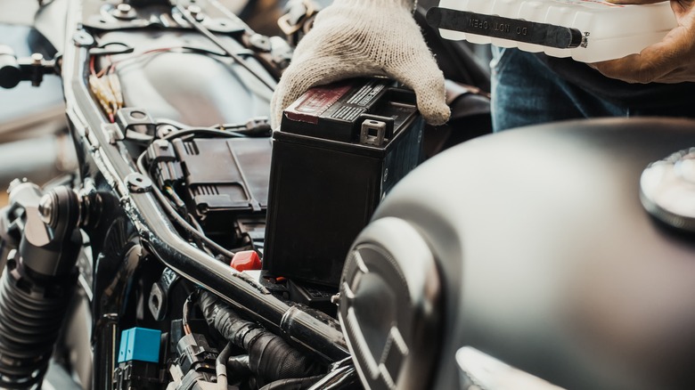 Person removing motorcycle battery