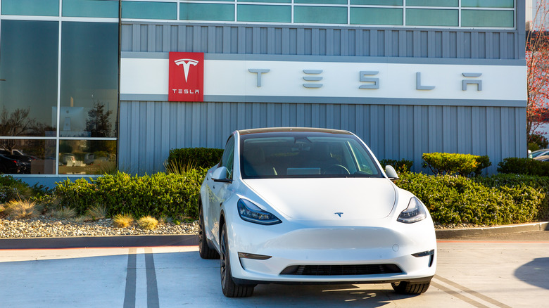 Tesla Model 3 parked outside a Tesla dealership building