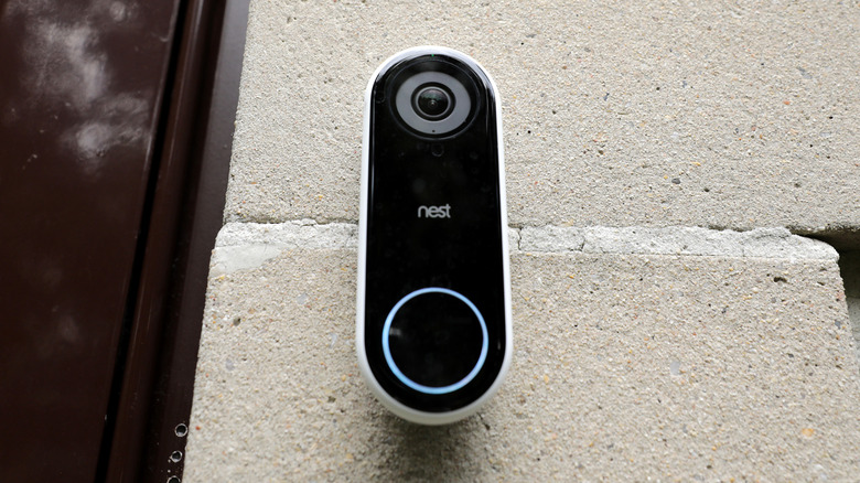 A Ring doorbell with a smartphone next to it