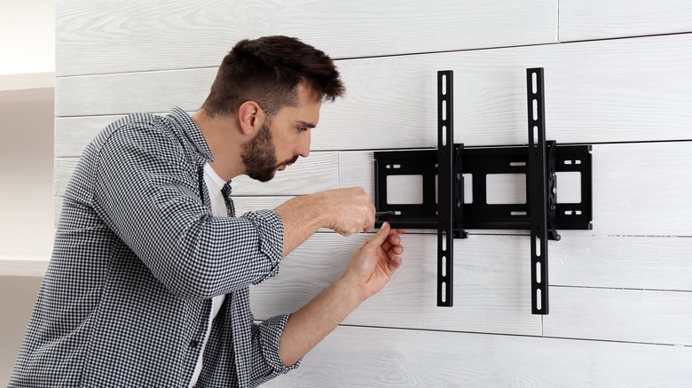 Man installing TV wall bracket