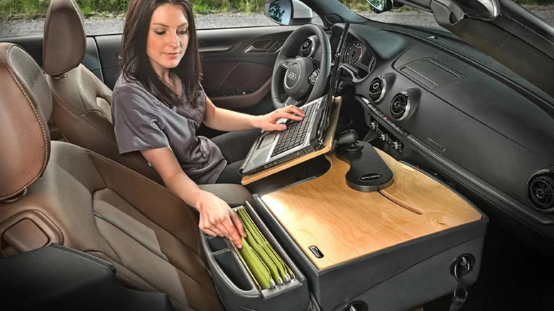 Girl in car working on laptop and looking through files