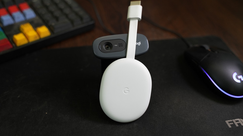 White Chromecast on the table next to a keyboard and gaming mouse