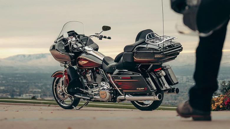 Rider in foreground looking at parked Harley-Davidson CVO road glide motorcycle