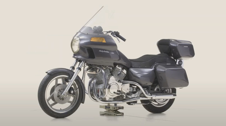 Grey Harley-Davidson Nova motorcycle on display stand against light grey background