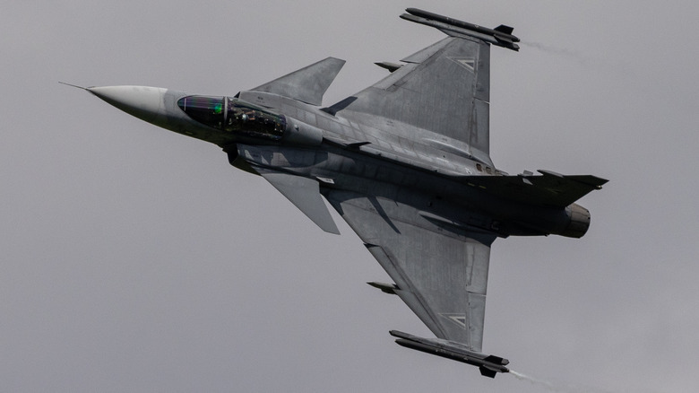 An Austrian Saab JAS-39C Grippen flying over grey skies at an air show