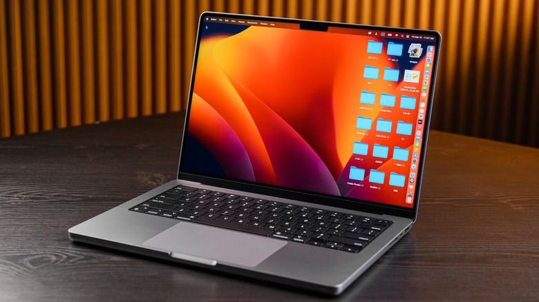 MacBook on a table with folders on the desktop