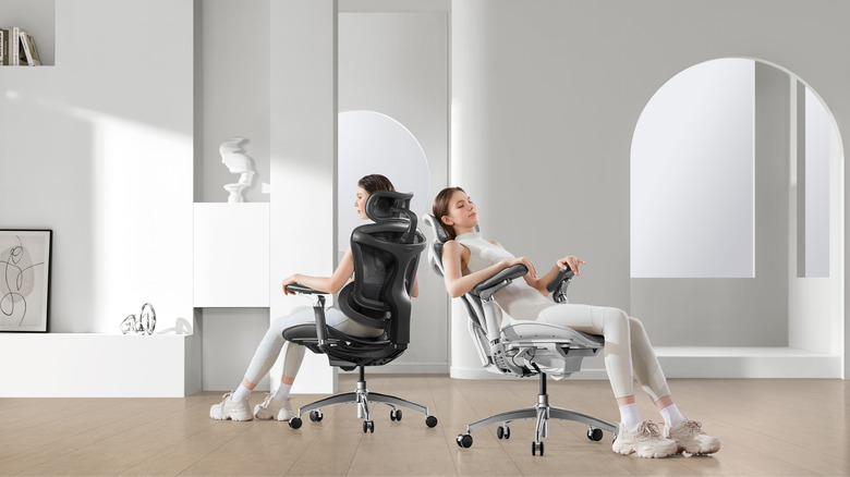 Two women sit in a room. One of them sits in a black Doro C300 Pro and the other sits in a light gray Doro C300 Pro.