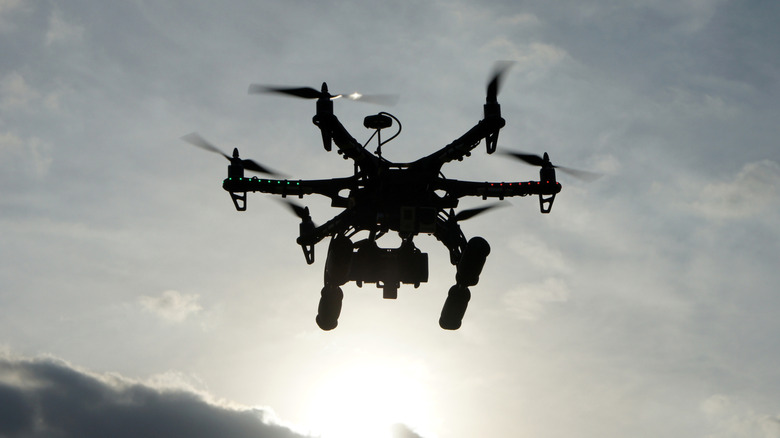 Drone hovering in the sky at sunset