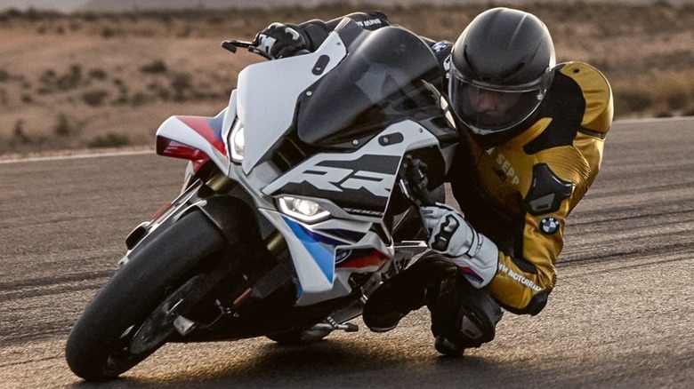 Riding a BMW S 1000 RR on a closed course. The rider has his knee down and is hanging off the bike