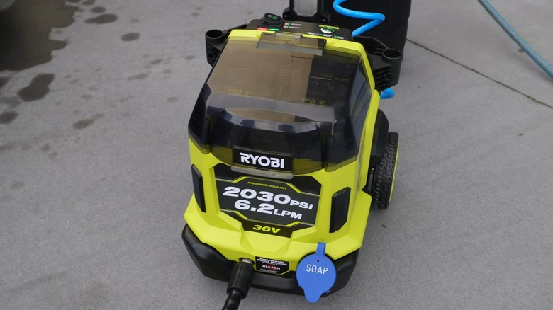 A Ryobi pressure washer on concrete outside.