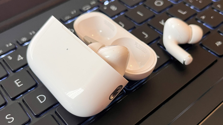 AirPods case and AirPod on a laptop keyboard