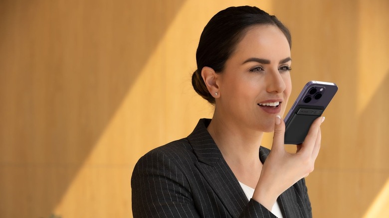 Woman using PLAUD Note during phone call.