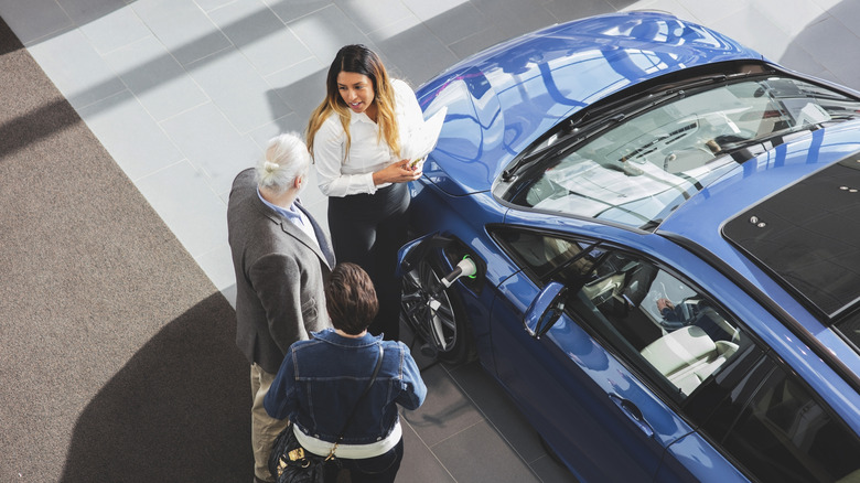 People talking to car salesperson