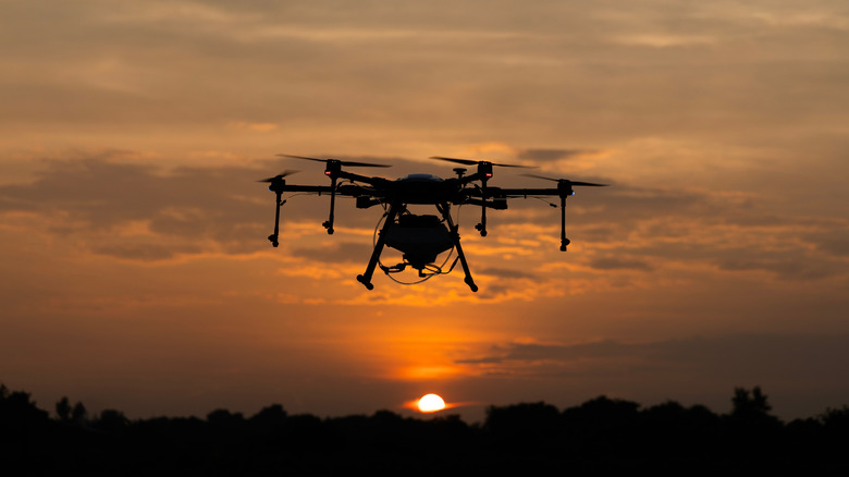 Drone flying in the air and facing the sunset