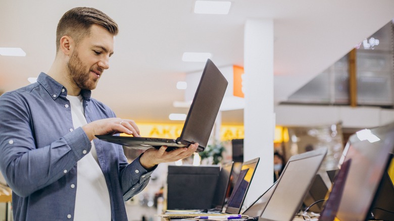 Man checking a laptop at electronic store