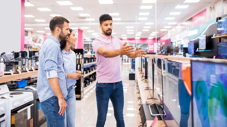 Employee showing a couple many different TVs