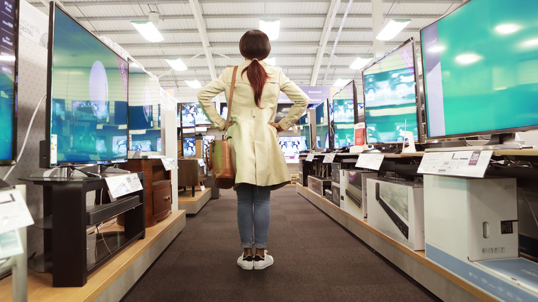 Woman standing in a store's TV aisle