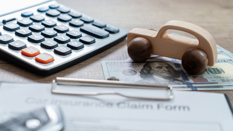 Calculator, toy car, money, and form on table