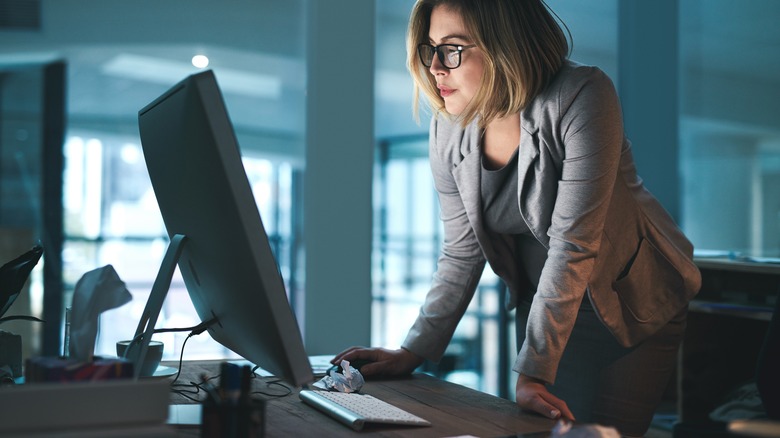 Woman, employee and reading on computer in office