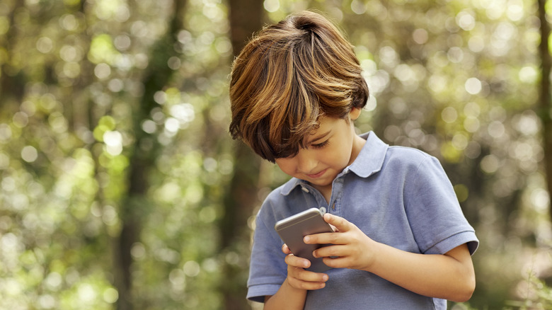 Boy intently looking at phone 